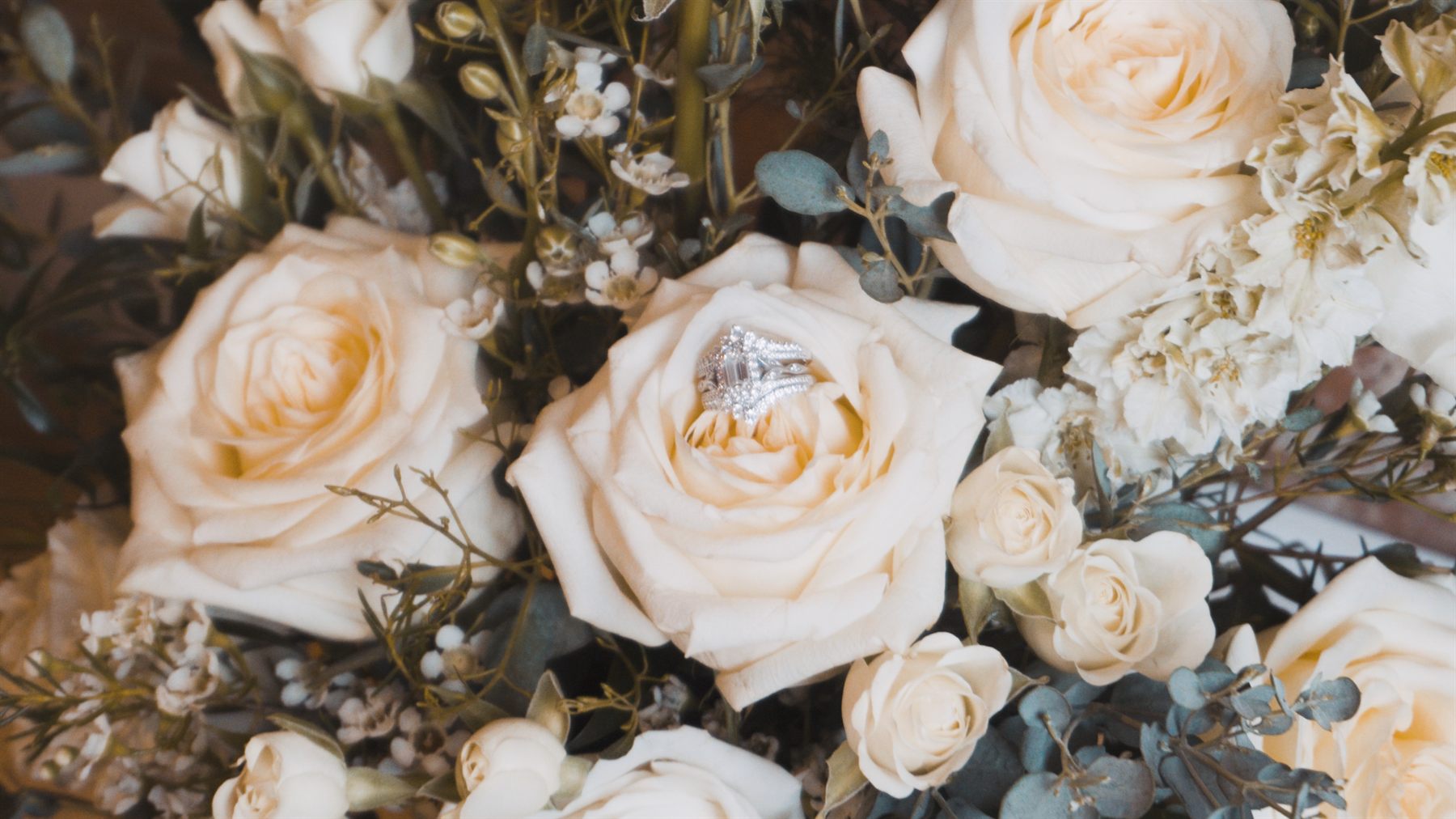 Close-up of white wedding flowers with rings in the bouquet